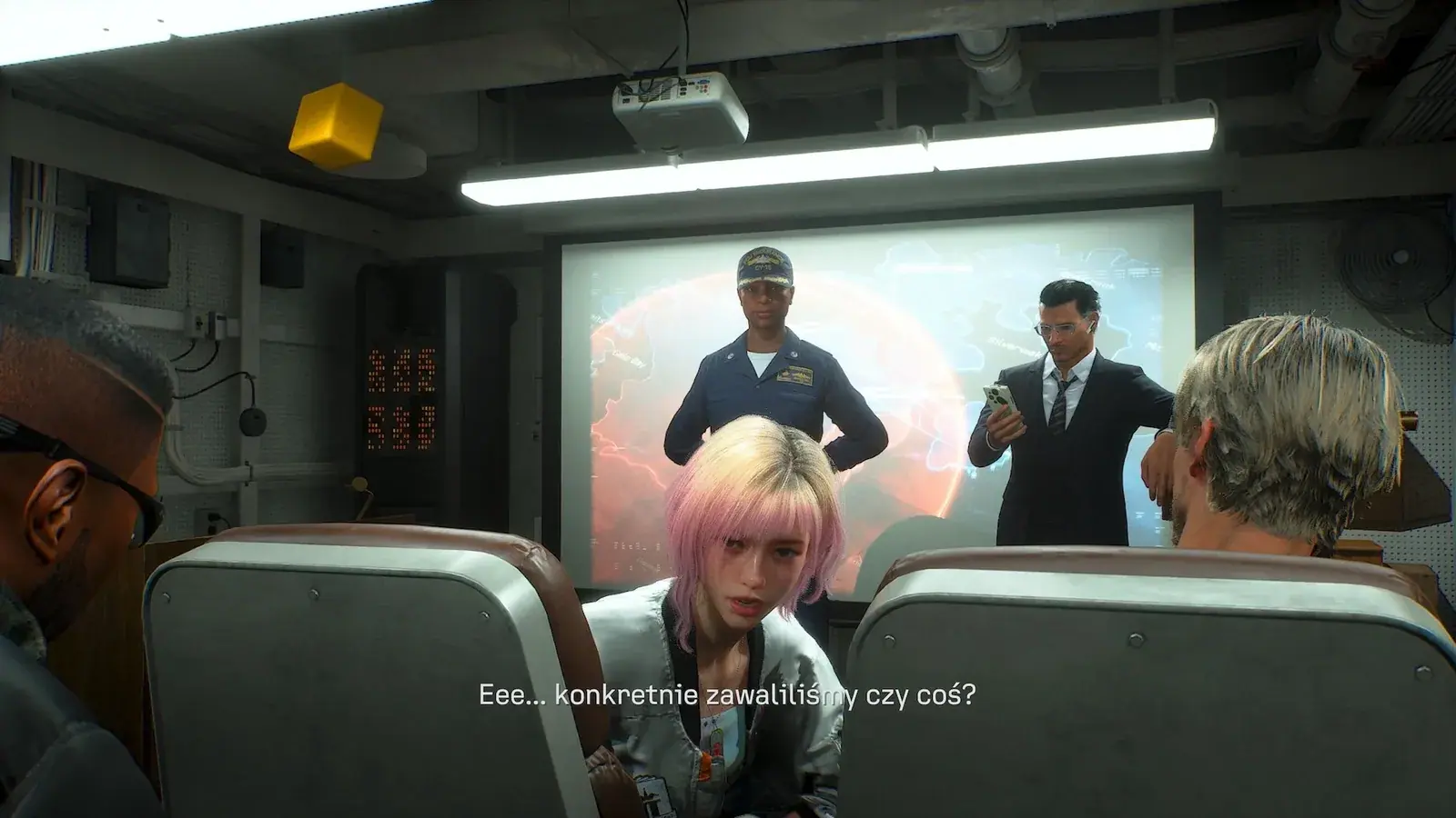 Tasha turning toward seated crew members during a carrier briefing