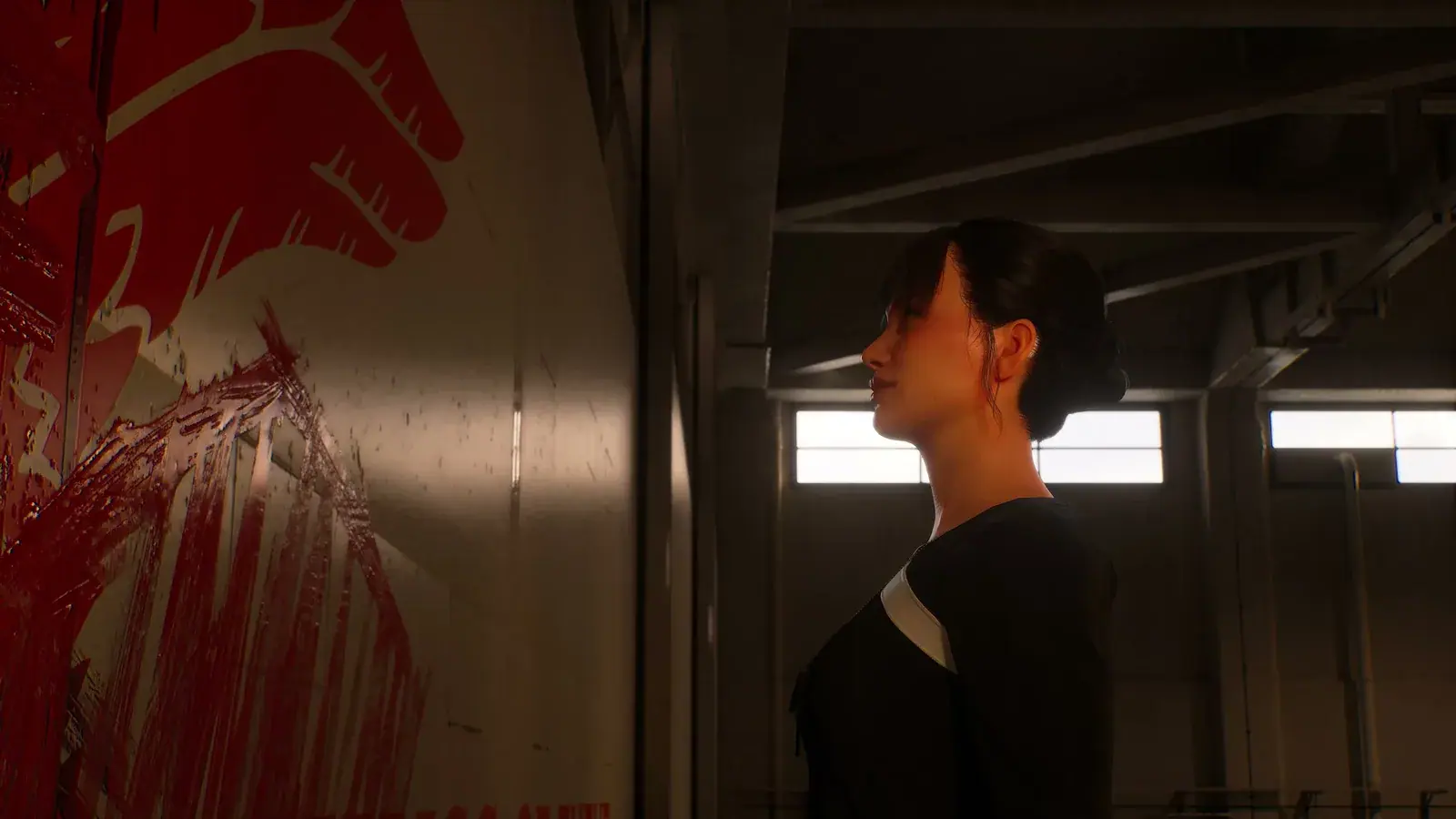 Kate Evans standing beside the red Five Wings sigil painted on a wall